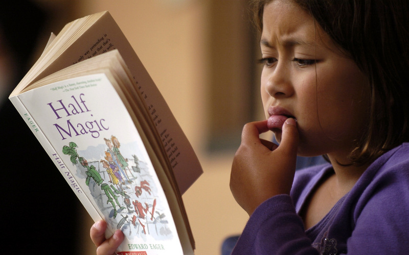 Claire Talbott, 7, of San Francisco, reads during a news conference addressing California Standardized Testing. (AP Photo/Benjamin Sklar)