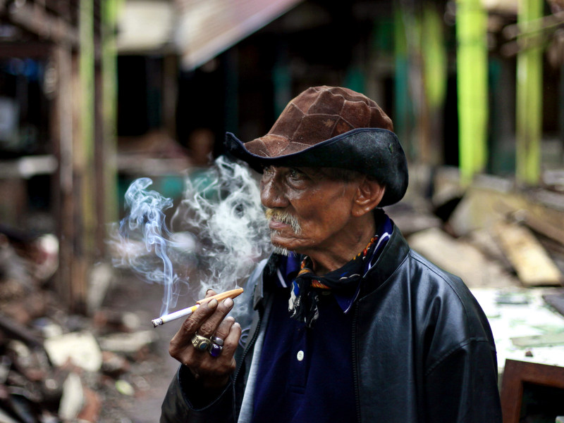 An Indonesian elderly man smokes cigarette in Jakarta, Indonesia, Wednesday, Feb. 1, 2012. (AP Photo/Dita Alangkara)