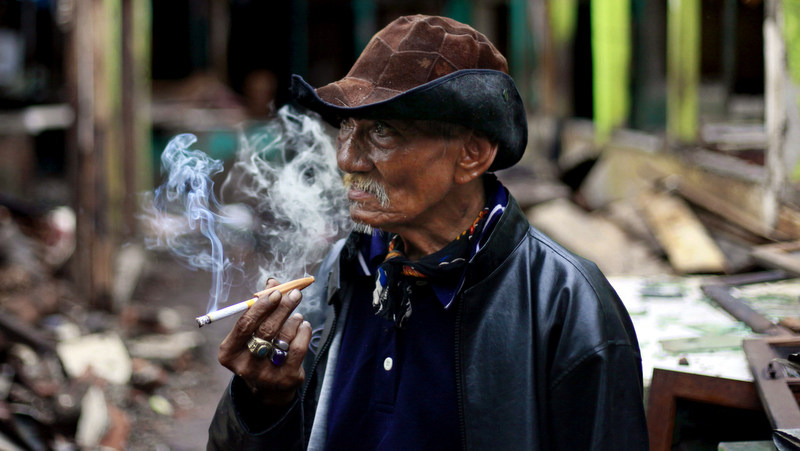 An Indonesian elderly man smokes cigarette in Jakarta, Indonesia, Wednesday, Feb. 1, 2012. (AP Photo/Dita Alangkara)