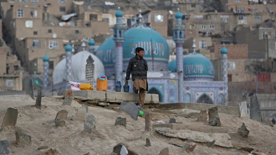 Haseeb, 13, an Afghan boy waits for customers to sell water in Kart-e Sakhi cemetery in Kabul, Afghanistan, Wednesday, Jan. 29, 2014. Children sell water in cemeteries for visitors to pour it on their relatives' graveyards. (AP Photo/Massoud Hossaini)
