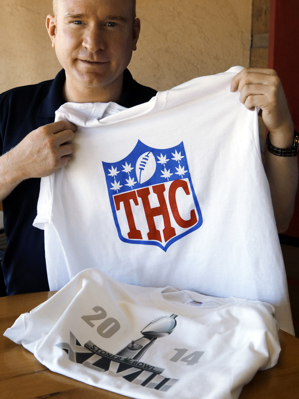 Bryan Weinman is pictured with two of his "Stoner Bowl" T-shirts in southeast Denver on Friday, Jan. 24, 2014. (AP Photo/Ed Andrieski)