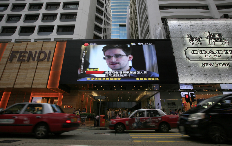 A TV screen shows a news report of Edward Snowden, a former CIA employee who leaked top-secret documents about sweeping U.S. surveillance programs, at a shopping mall in Hong Kong Sunday, June 23, 2013. (AP Photo/Vincent Yu, File)