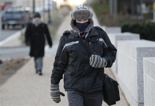 A person walks in frigid temperatures near Constitution Avenue, Tuesday, Jan. 7, 2014, in Washington. The National Weather Service said the mercury bottomed out at 3 degrees before sunrise at Baltimore-Washington Thurgood Marshall International Airport, with a wind chill of minus 16. (AP Photo/Luis M. Alvarez)