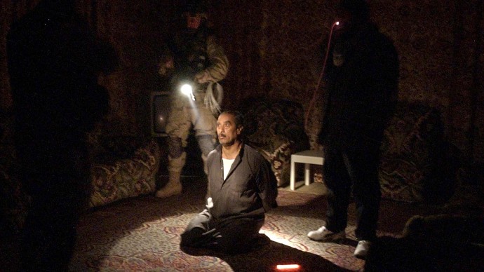 In this Wednesday, Jan. 14, 2004 file photo, a man suspected of involvement in attacks on coalition forces is questioned in the living room of his home during a raid by the 82nd Airborne Division near Fallujah, Iraq. In 2014, the city's fall to al-Qaida-linked forces has touched a nerve for the service members who fought and bled there. (AP Photo/Julie Jacobson)
