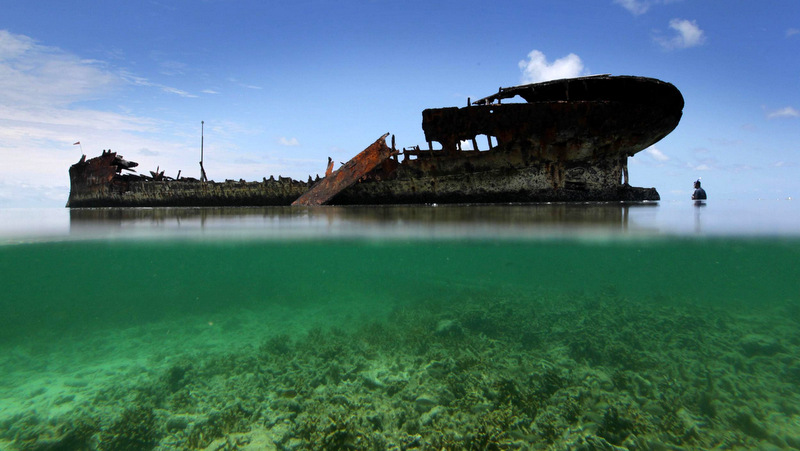 Split-shot of a rusted hulk of an abandoned ship at the entrance to Heron Island. The excursion to Heron Island is a fact finding mission to a research station there as part of Greenpeace's Save the Reef campaign. (Photo courtesy of Greenpeace Australia)