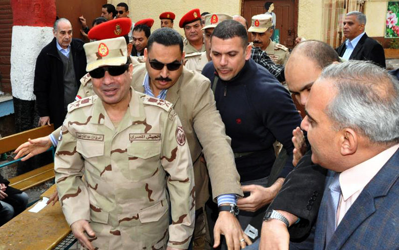 In this Tuesday, Jan. 14, 2014 file photo released by the Egyptian Defense Ministry, Defense Minister Gen. Abdel-Fattah el-Sissi, left, visits a polling site in the Heliopolis neighborhood of Cairo, Egypt, on the first day of voting in the constitutional referendum. Egypt’s state TV said Monday, Jan. 27, 2014 that the country’s Interim President issued a presidential decision, promoting the powerful army chief who led the July coup removed Islamist president from power, to the top military rank of marshal. (AP Photo/Egyptian Defense Ministry via Facebook, File)