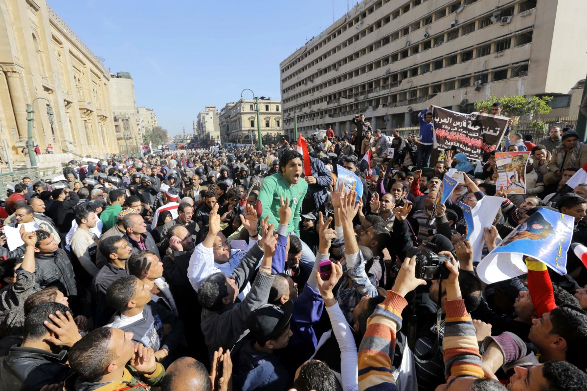 Egyptians shout anti-terrorism slogans as they demonstrate in front the site of a blast at the Egyptian police headquarters, at right, and the Museum of Islamic Art, at left, in downtown Cairo, Egypt, Friday, Jan. 24, 2014. A car bomb struck the main Egyptian police headquarters Friday in the heart of Cairo, killing several people in a hugely symbolic attack on the eve of the third anniversary of the 2011 uprising that toppled longtime autocratic ruler Hosni Mubarak. (AP Photo/Amr Nabil)