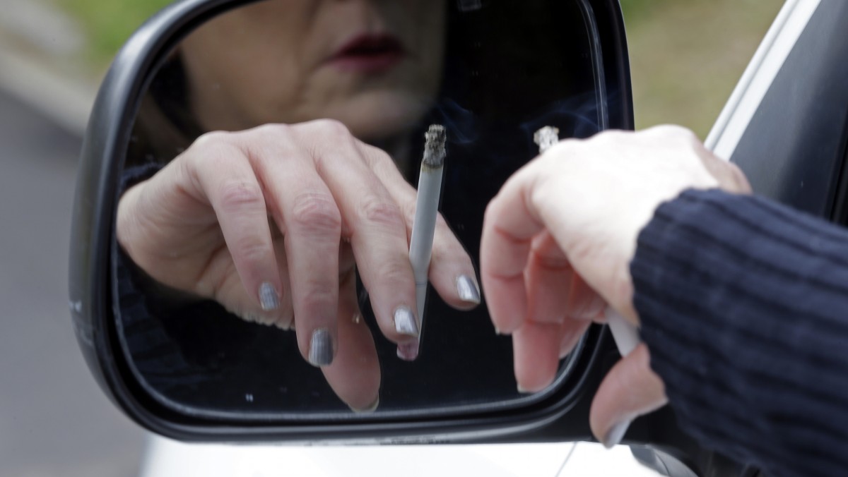 In this Saturday, March 2, 2013 file photo, a woman smokes a cigarette while sitting in her truck in Hayneville, Ala. Anti-smoking measures have saved roughly 8 million U.S. lives since a landmark 1964 report linking smoking and disease, a study estimates, yet the nation's top disease detective says dozens of other countries have surpassed U.S. efforts to stop many tobacco-related harms. The study and comments were published online Tuesday, Jan. 7, 2014 in the Journal of the American Medical Association. This week’s journal commemorates the 50th anniversary of the surgeon general report credited with raising alarms about the dangers of smoking. (AP Photo/Dave Martin, File)