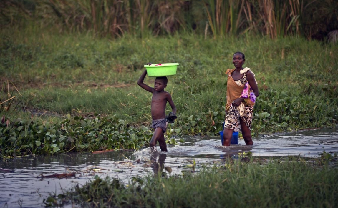 Displaced people who fled the recent fighting between government and rebel forces in Bor by boat across the White Nile, bathe, wash clothes and gather water from the Nile in the town of Awerial, South Sudan Wednesday, Jan. 1, 2014. (AP Photo/Ben Curtis)