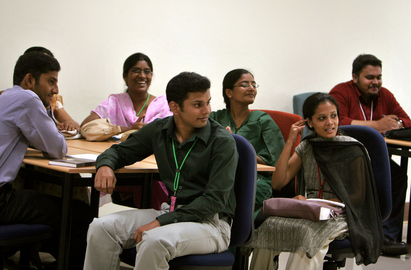 Employees smile as they react to their colleague during a class at the training center of Infosys Technologies sprawling corporate campus in Mysore, India, Wednesday, Jan. 31, 2007. In the United States and Europe, India may appear to have a bottomless supply of cheap, educated workers just looking for ways to soak up more outsourced Western jobs. But things look far different in India, where industry is spending hundreds of millions of dollars in a frantic attempt to make sure its profit-making high-tech machine fueled by its immense English-speaking talent pool keeps producing. (AP Photo/Aijaz Rahi)
