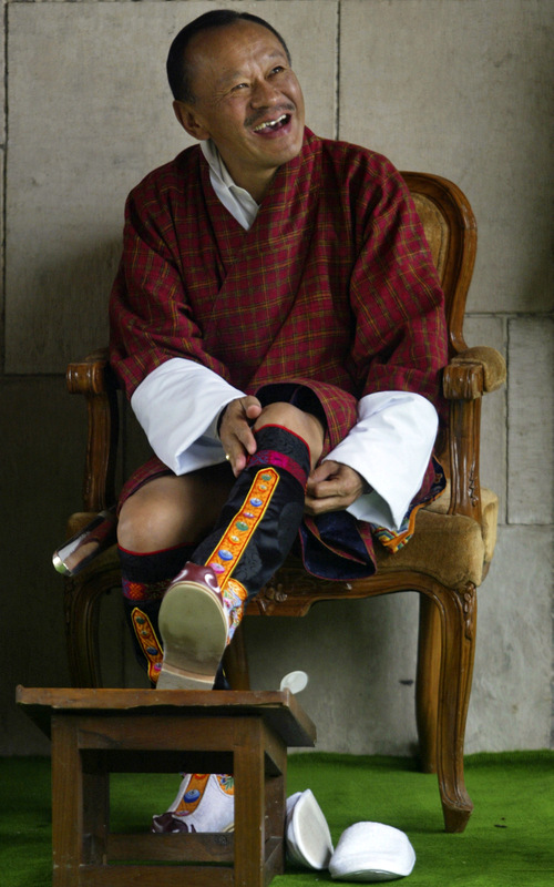 Bhutan's Prime Minister Lyonchen Jigmi Y Thinley, wears his shoes after paying tribute at Mahatma Gandhi memorial in New Delhi, India, Wednesday, July 16, 2008. (AP Photo/Mustafa Quraishi)