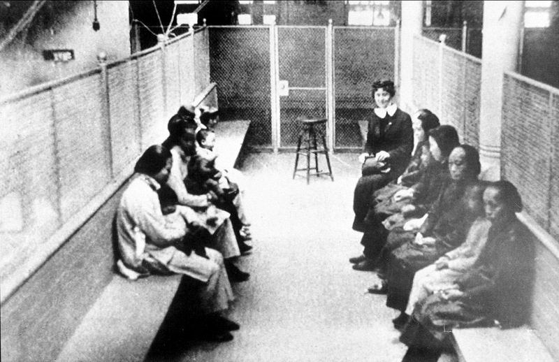In this file photo from the 1920s, a group of Chinese and Japanese women and children wait to be processed as they are held in a wire mesh enclosure at internment barracks in Angel Island, Calif. Chinese immigrants were essential to the founding of California. (AP Photo, file)
