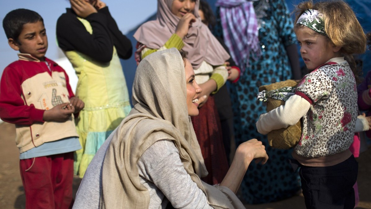 In this Sunday February 23, 2014 photo released by the United Nations High Commission for Refugees, actress and U.N. special envoy Angelina Jolie, center foreground, meets with young Syrian refugees at an informal tented settlement in Zahleh, Bekaa Valley, Lebanon.