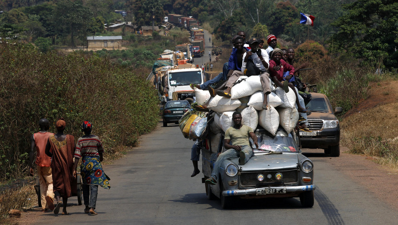 A vehicle filled with people and heavy load, precedes a convoy of over 100 trucks arriving in the Central African Republic capital Bangui from Cameroon