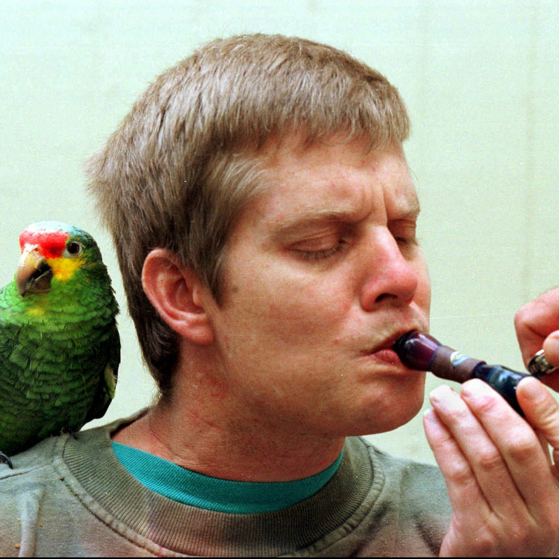 Curtis Rood,36, a Cohen House resident with limited mobility, smokes marijuana with the assistance of another resident on Sunday, Nov. 30,1997 in San Francisco. Cohen House provides an assisted living environment for individuals with the AIDS virus. Most of the residents use marijuana for its medicine benefits in alleviating nausua, pain, and helping to stimulate the appetite. Curtis' parrot and self proclaimed best friend, Kona, rests on his shoulder while in the backyard of Cohen House. (AP photo/Julie Stupsker)