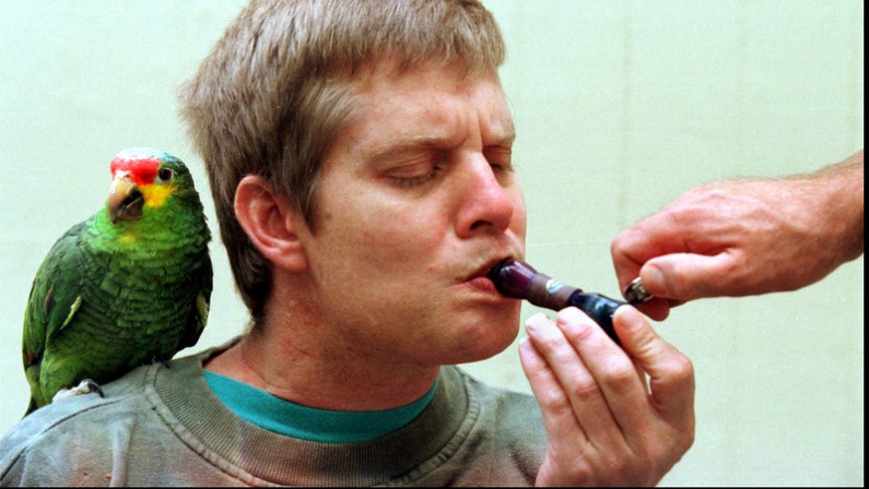 Curtis Rood,36, a Cohen House resident with limited mobility, smokes marijuana with the assistance of another resident on Sunday, Nov. 30,1997 in San Francisco. Cohen House provides an assisted living environment for individuals with the AIDS virus. Most of the residents use marijuana for its medicine benefits in alleviating nausua, pain, and helping to stimulate the appetite. Curtis' parrot and self proclaimed best friend, Kona, rests on his shoulder while in the backyard of Cohen House. (AP photo/Julie Stupsker)