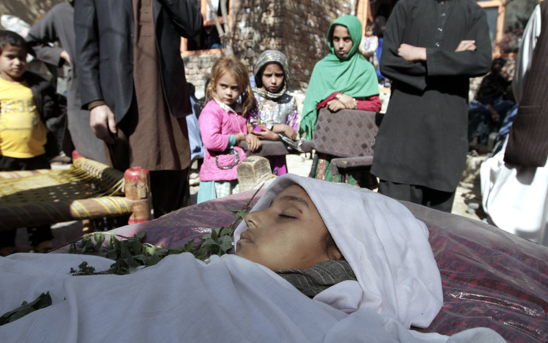 Relatives surround the body of a ten-year-old Afghan girl who was killed by a roadside bomb explosion on the outskirts of Kabul, Afghanistan. (AP Photo/Rahmat Gul, File)
