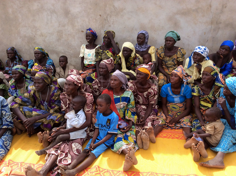 In this photo taken with an iPad on Friday, Jan. 31, 2014, women and children who survived attacks by Boko haram sits outside a compound at St. Paul's Roman Catholic Church, in Wada Chakawa, Yola, Nigeria.. (AP Photo/ Ibrahim Abdulaziz)