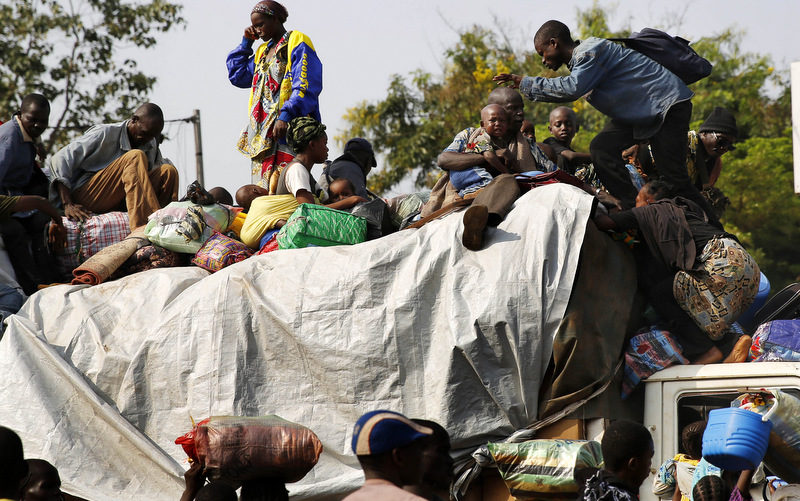 At PK12, the last checkpoint at the exit of the town, thousands of Muslim residents from Bangui and Mbaiki flee the Central African Republic town of Bangui in a mass exodus using cars, pickups, trucks, lorries and motorcycles, escorted by Chadian troops on Friday, Feb. 7, 2014. Tit-for-tat violence killed more than 1,000 people in Bangui alone in a matter of days in December. An untold number have died in the weeks that followed, with most of the attacks in Bangui targeting Muslims. (AP Photo/Jerome Delay)