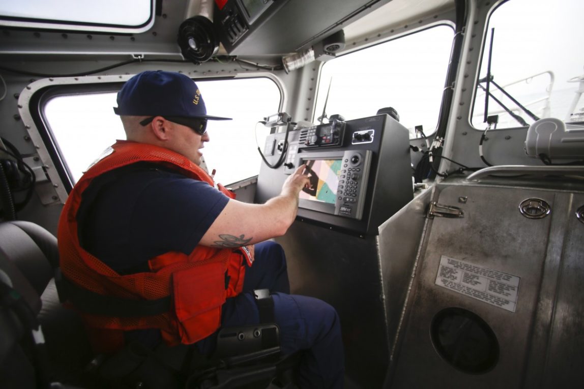 Coast Guard officer following traffic on his screen while facing a dense fog