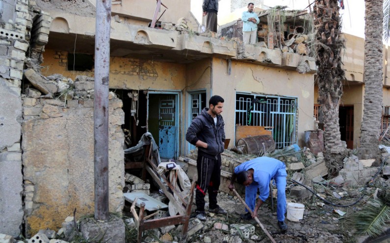 Civilians sift through rubble and stand in the ruins of a home 
