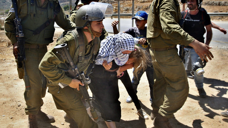 Two Palestinian children try to help Palestinian Nariman Tamimi avoid arrest by Israeli soldiers during a protest against the expansion of the nearby Jewish settlement of Halamish in the West Bank village of Nabi Saleh near Ramallah, Friday, Aug 24, 2012. (AP Photo/Majdi Mohammed)