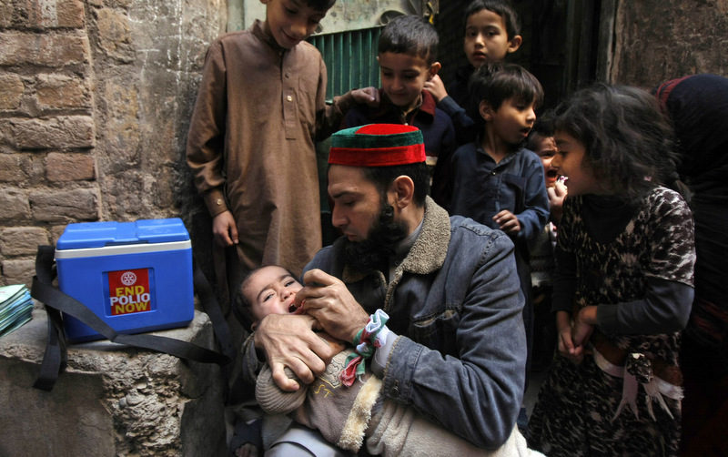 In this Feb. 9, 2014 photo, a Pakistani health worker vaccinates a child against polio, in Peshawar, Pakistan. Pakistan’s beleaguered battle to eradicate polio is threatening a global, multi-billion dollar campaign to wipe out the disease worldwide. Because of Pakistan, the virus is spreading to countries that were previously polio free, say U.N officials. “The largest poliovirus reservoir of the world,” is in Peshawar, the capital of Pakistan’s northwest Khyber Pukhtunkhwa province, which borders Afghanistan, according to the World Health Organization. (AP Photo/Mohammad Sajjad)