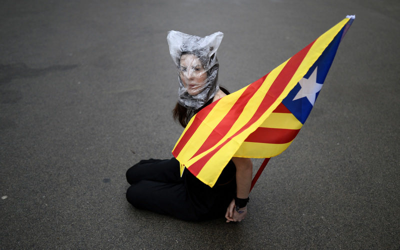 A pro-independence protester holds a "estelada" flag, that symbolizes Catalonia's independence, as lawmakers vote on whether to seek the right to hold a referendum on independence from Spain at the Parliament of Catalonia in Barcelona, Spain, Thursday, Jan. 16, 2014. (AP Photo/Manu Fernandez)