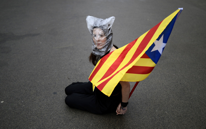 A pro-independence protester holds a "estelada" flag, that symbolizes Catalonia's independence, as lawmakers vote on whether to seek the right to hold a referendum on independence from Spain at the Parliament of Catalonia in Barcelona, Spain, Thursday, Jan. 16, 2014.  (AP Photo/Manu Fernandez)