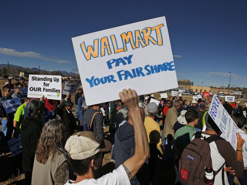 Colorado Walmart employees and supporters join nationwide protests, in front of a Walmart store in Lakewood, Colo., Friday, Nov. 29, 2013, for Walmart to publicly commit to improving labor standards.  Black Friday, the day after Thanksgiving, is the nation's biggest shopping day of the year. (AP Photo/Brennan Linsley)