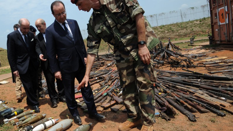French President Francois Hollande, second from right, inspects weapons confiscated from ex-Seleka rebels and anti-Balaka militia by the French military during operation Sangaris, as they are displayed at a French military base in Bangui, Central African Republic, Friday, Feb. 28, 2014. It is Hollande's second trip to Bangui since the beginning of Operation Sangaris in December. Thousands of international troops dispatched to volatile Central African Republic are there to help keep the country from breaking apart, France's president said Friday, days after the French parliament voted to prolong the country's mission in its former colony wracked by violence between Christians and Muslims (AP Photo/Sia Kambou, Pool)