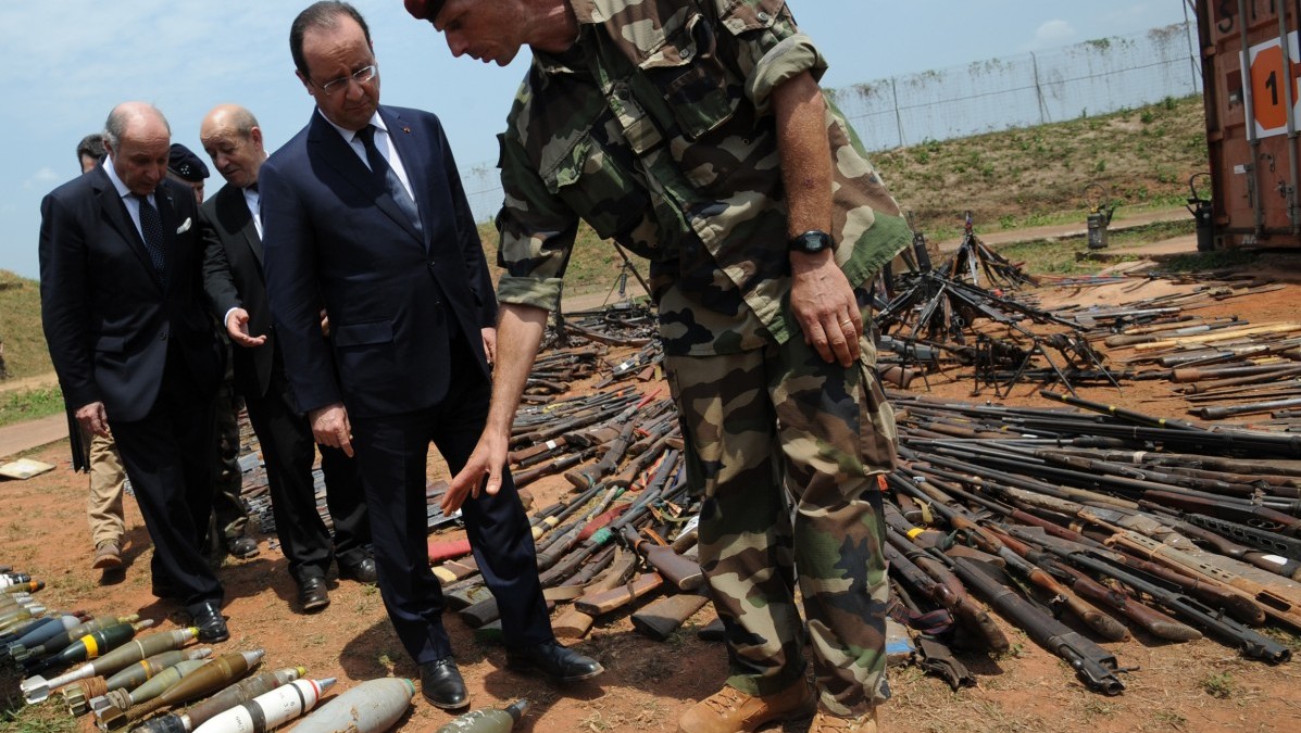 French President Francois Hollande, second from right, inspects weapons confiscated from ex-Seleka rebels and anti-Balaka militia by the French military during operation Sangaris, as they are displayed at a French military base in Bangui, Central African Republic, Friday, Feb. 28, 2014. 