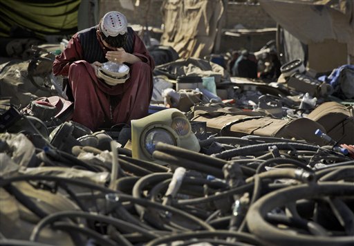 FILE-In this file picture taken Nov. 2, 2013 photo an Afghan scrap dealer checks to see if a head light bought as junk from the U.S. military is working at a junk yard in Kandahar, southern Afghanistan. As the United States military packs up to leave Afghanistan, ending 13 years of war, it is looking to sell or dispose of billions of dollars in military hardware, including its sophisticated and highly specialized mine resistant vehicles, but finding a buyer is complicated in a region where relations between neighboring countries are mired in suspicion and outright hostility.(AP Photo/Anja Niedringhaus, file)