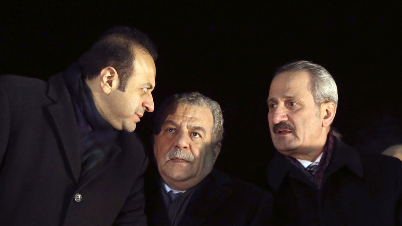 Turkey's Economy Minister Zafer Caglayan, right, Interior Minister Muammer Guler, center, and EU Affairs Minister Egemen Bagis speak at the Esenboga Airport, Ankara, Turkey. Guler and Caglayan resigned from their posts days after their sons were arrested in a massive corruption and bribery scandal, Dec. 24, 2013. (AP Photo)