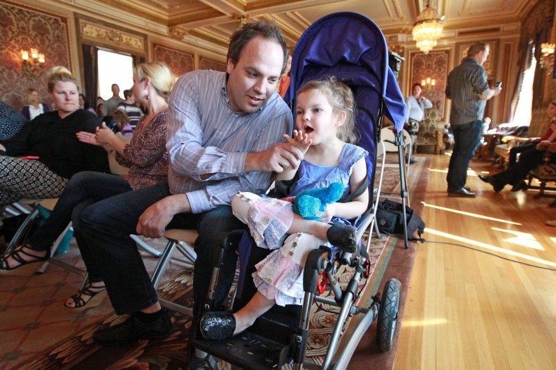 Clinton Atwater plays with his daughter Asia Skye Atwater, 7, before the H.B 105 bill signing ceremony at the Utah State Capitol Tuesday, March 25, 2014, in Salt Lake City. Parents of Utah children with severe epilepsy are cheering a new state law that allows them to obtain a marijuana extract they say helps with seizures, but procuring it involves navigating a thorny set of state and federal laws. Utah's Republican Gov. Gary Herbert has already approved the law and held the signing ceremony Tuesday afternoon. The new law doesn't allow medical marijuana production in Utah but allows families meeting certain restrictions to obtain the extract from other states. (AP Photo/Rick Bowmer)