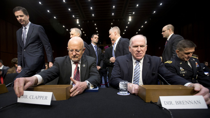 Director of National Intelligence James Clapper, foreground left, and CIA Director John Brennan, foreground right, take their seats on Capitol Hill in Washington, Wednesday, Jan. 29, 2014, prior to testifying before the Senate Intelligence Committee hearing.