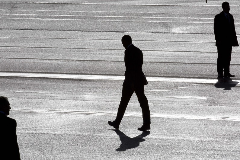 President Barack Obama, center, and two secret service agents are silhouetted as he walks towards Marine One helicopter upon arrival at Schiphol Amsterdam Airport, Netherlands, Monday March 24, 2014. Obama will attend the two-day Nuclear Security Summit in The Hague. (AP Photo/Peter Dejong, POOL)