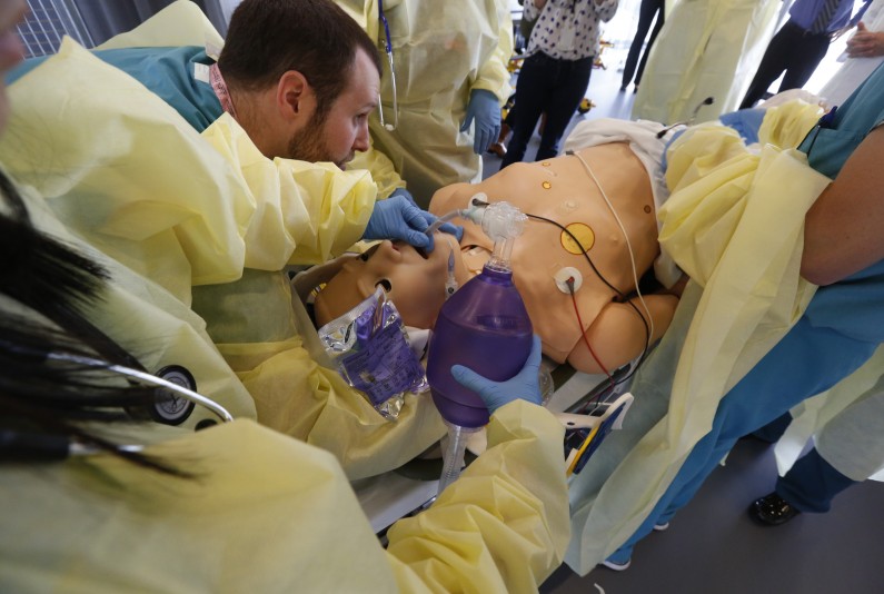 In this Tuesday, Feb. 11, 2014 photo, surgical residents along surgical residents among with experienced surgeons train on a mannequin at the Surgical Simulation and Training Laboratory in the Department of Surgery at Cedars-Sinai Medical Center in Los Angeles. The operating room of the future is being tested in an ongoing experiment aimed at breaking down barriers that bog down care through open communication and better use of technology. (AP Photo/Nick Ut)