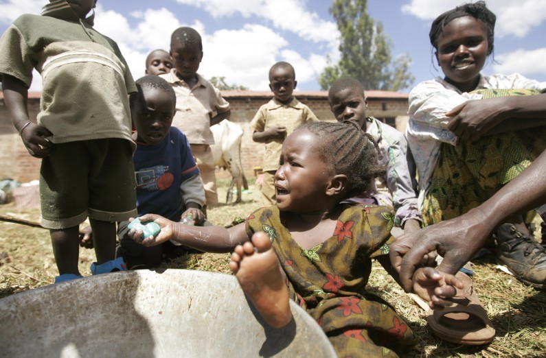 FILE - In this Sunday, Jan. 6, 2008 file photo, a young displaced girl washes herself with soap from a metal bowl in a makeshift camp in Noigam Primary School in Kachibora village, Kenya, following post-election violence. A treaty that African nations hope will lead to the fair and humane treatment of people displaced in their own countries went into force Thursday, Dec. 6, 2012, more than three years after it was conceived by the African Union. (AP Photo/Ben Curtis, File)