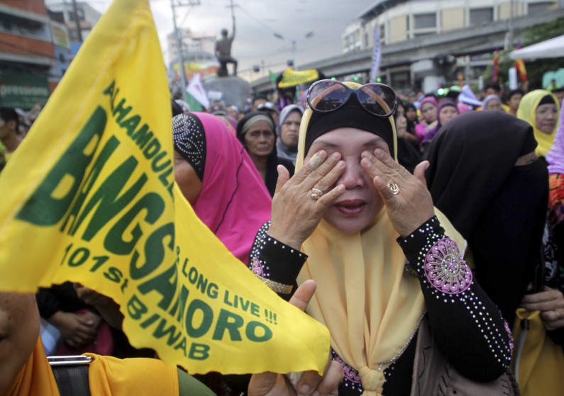 Filipino Muslims wipe their tears after learning that a peace accord has been signed between Moro Islamic Liberation Front leaders and Philippine President Benigno Aquino III during a rally on Thursday March 27, 2014 outside the presidential palace in Manila, Philippines. The Philippine government signed a peace accord with the country's largest Muslim rebel group on Thursday, the culmination of years of negotiations and a significant political achievement for President Benigno Aquino III. (AP Photo)