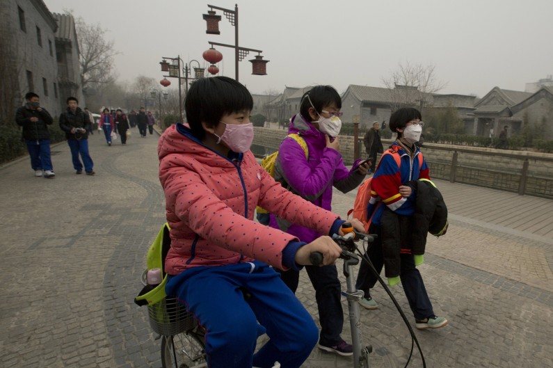 FILE - In this Tuesday, Feb. 25, 2014 file photo, children wearing masks walk home after school in Beijing, China. Air pollution kills about 7 million people worldwide every year according to a new report from the World Health Organization published Tuesday, March 25, 2014. The agency said air pollution triggers about 1 in 8 deaths and has now become the single biggest environmental health risk, ahead of other dangers like second-hand smoke. (AP Photo/Ng Han Guan, File)