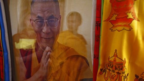 A Tibetan Buddhist monk is reflected on a portrait of spiritual leader the Dalai Lama during festivities marking the last day of the Tibetan New Year, or Losar, in Kathmandu, Nepal, Tuesday, March 4, 2014. Tibetans across the world marked the arrival of the Wood Horse year with prayers and festivities. (AP Photo/Niranjan Shrestha)