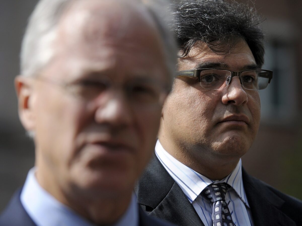 Former CIA officer John Kiriakou, right, listens as his attorney Robert Trout speaks with reporters outside of the U.S. District Court in Alexandria, Va., Oct. 23, 2012, after Kiriakou pleading guilty, in a plea deal, to leaking the names of covert operatives to journalists. (AP/Cliff Owen)