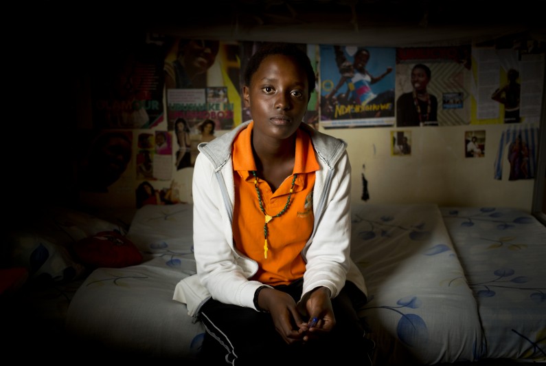 In this photo taken Monday, March 24, 2014, student Sharon Kalisa, 17, whose favorite subject is history and particularly genocide studies, sits in her bedroom at the Agahozo-Shalom Youth Village near Rwamagana, in Rwanda. Most of the kids in a Rwandan school set amid the lush green, rolling hills of eastern Rwanda dont identify themselves as Hutu or Tutsi. Thats a positive sign for Rwanda, which is now observing the 20th anniversary of its genocide, a three-month killing spree that, according to the official Rwandan count, left more than 1 million people dead, most of them Tutsis killed by Hutus. The teenagers attending the Agahozo-Shalom Youth Village, a school with dorms that creates tight-knit student families, say the ethnic slaughter that their parents or grandparents were a part of either as victims or perpetrators wont be repeated. The school director echoes the sentiment. (AP Photo/Ben Curtis)
