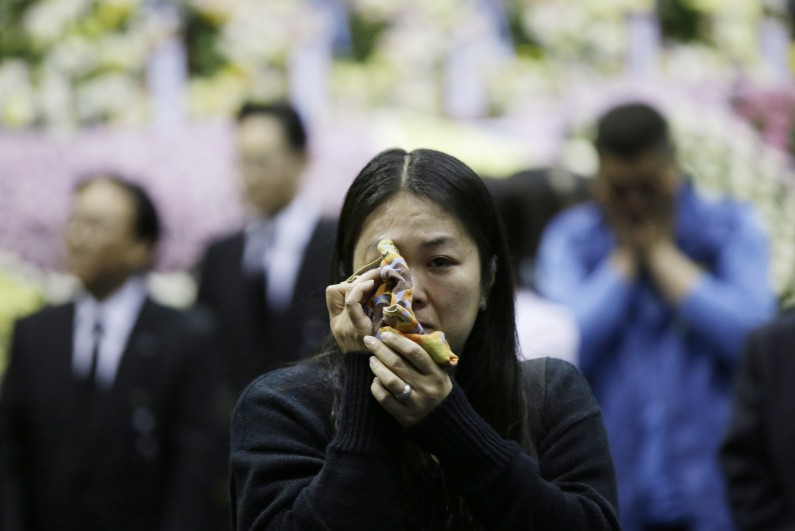 A South Korean Lee Won-a, 40, wipes her tear after she pays tribute to the victims of the sunken ferry Sewol at a group memorial altar in Ansan, south of Seoul, South Korea, Wednesday, April 30, 2014. Two weeks after a ferry sank off South Korea's southern cost, divers have recovered 212 bodies from the wreckage, but they fought strong currents and floating debris inside the ship Wednesday as they searched for 90 passengers still missing. (AP Photo/Lee Jin-man)
