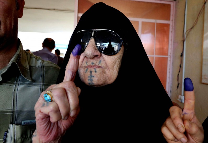 An Iraqi elderly woman shows she ink-stained finger after casting her vote inside a polling station for parliamentary elections in Baghdad, Iraq, Wednesday, April 30, 2014. Iraq is holding its third parliamentary elections since the U.S.-led invasion that toppled dictator Saddam Hussein.  More than 22 million voters are eligible to cast their ballots to choose 328 lawmakers out of more than 9,000 candidates. (AP Photo/Karim Kadim)