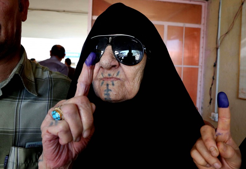An Iraqi elderly woman shows she ink-stained finger after casting her vote inside a polling station for parliamentary elections in Baghdad, Iraq, Wednesday, April 30, 2014. Iraq is holding its third parliamentary elections since the U.S.-led invasion that toppled dictator Saddam Hussein. More than 22 million voters are eligible to cast their ballots to choose 328 lawmakers out of more than 9,000 candidates. (AP Photo/Karim Kadim)