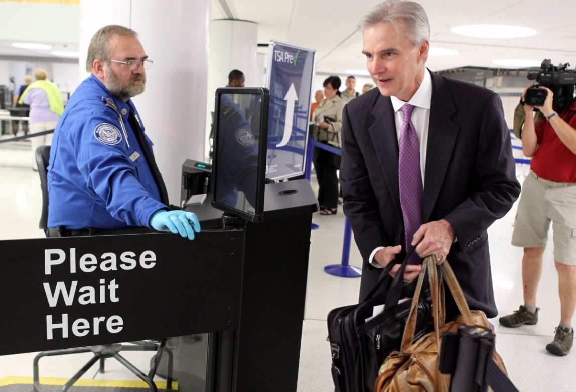 Transportation Security Administration agent Kevin Effan, left, allows a screened passenger to board his American Airlines flight. (AP Photo)