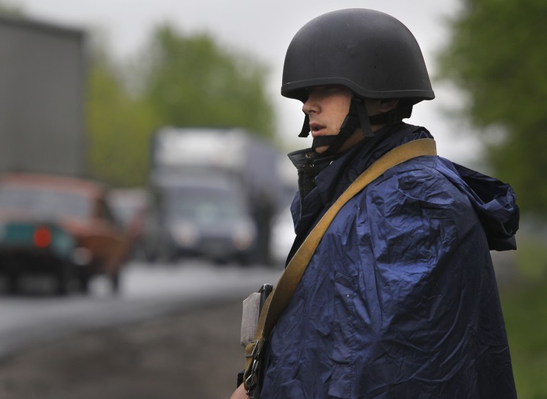 Ukrainian government soldier guards a checkpoint near the village of Dolina, 30 kilometers (18 miles) from Slovyansk, eastern Ukraine, Tuesday, April 29, 2014. The European Union on Tuesday released the names of 15 new targets of sanctions because of their roles in the Ukraine crisis. The list includes Gen. Valery Gerasimov, chief of the Russian General Staff and first deputy defense minister, and Lt. Gen. Igor Sergun, identified as head of GRU, the Russian military intelligence agency. (AP Photo/Sergei Grits)