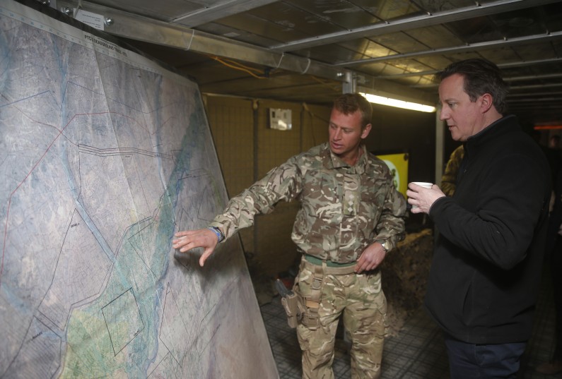 Britain's Prime Minister David Cameron, listens to a briefing by a British army officer at the forward operating base Sterga II at Helmand province in southern Afghanistan, Monday, Dec. 16, 2013.(AP Photo/Lefteris Pitarakis, pool)